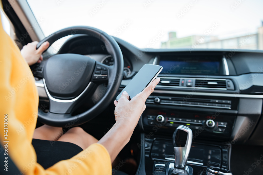Close up image with female driver and blank phone screen