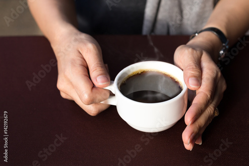 Woman hands holding hot coffee cup