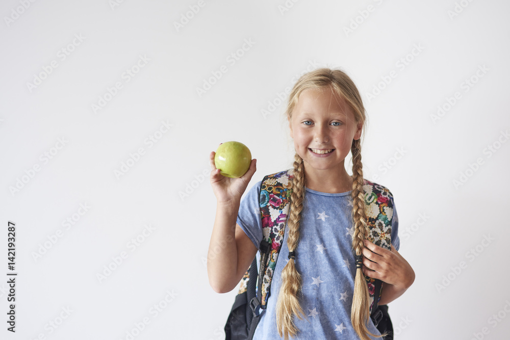 Waist up of student girl holding an apple Waist up of student girl holding an apple