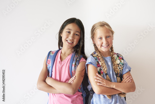 Portrait of two pretty girls with backpacks