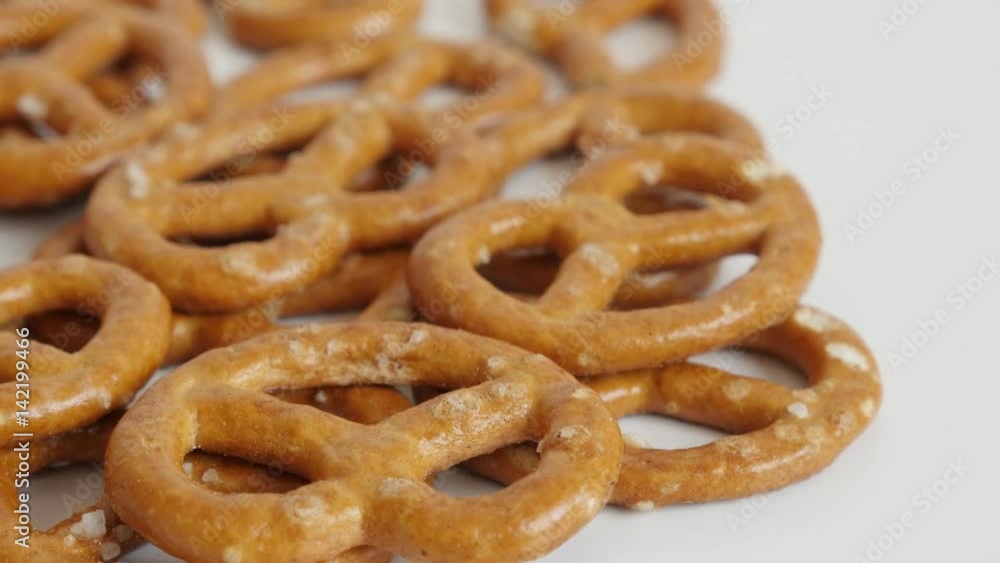 Slow tilt tasty pretzel snack on white background 4K 2160p 30fps UltraHD footage - Tilting on baked bread product made from dough close-up 3840X2160 UHD video Slow tilt tasty pretzel snack on white background 4K 2160p 30fps UltraHD footage - Tilting on baked bread product made from dough close-up 3840X2160 UHD video