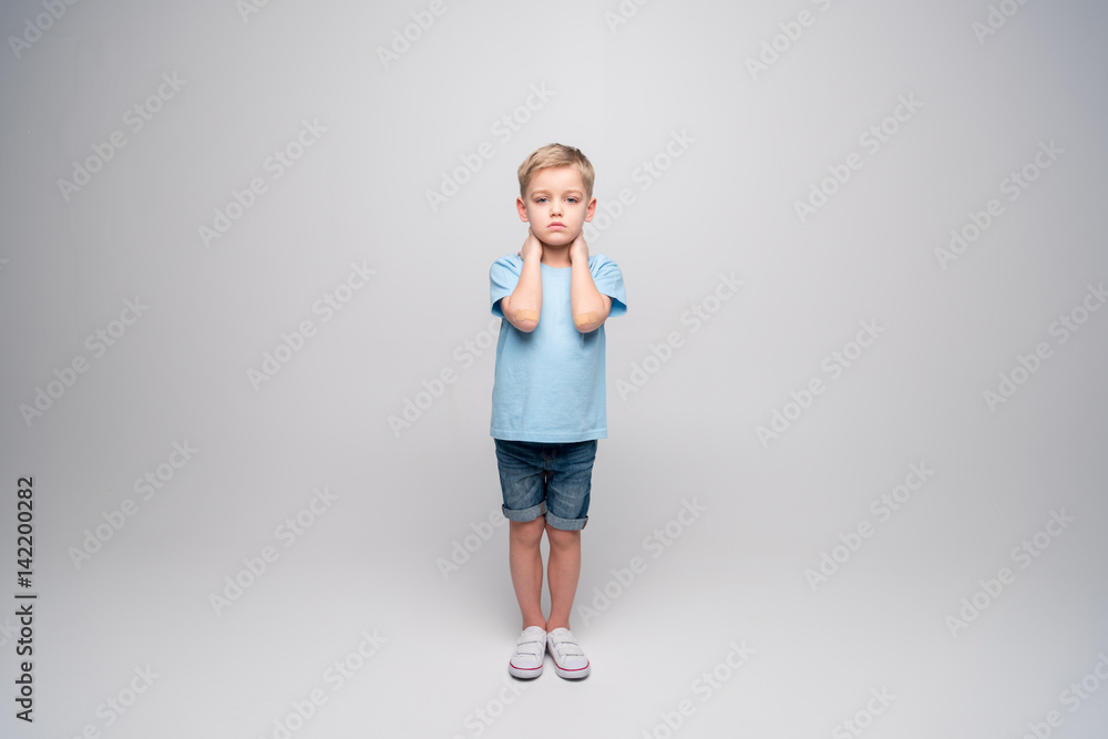 Little boy with patches on elbows