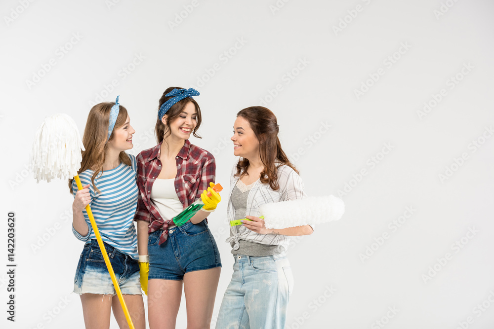 Young women with cleaning supplies