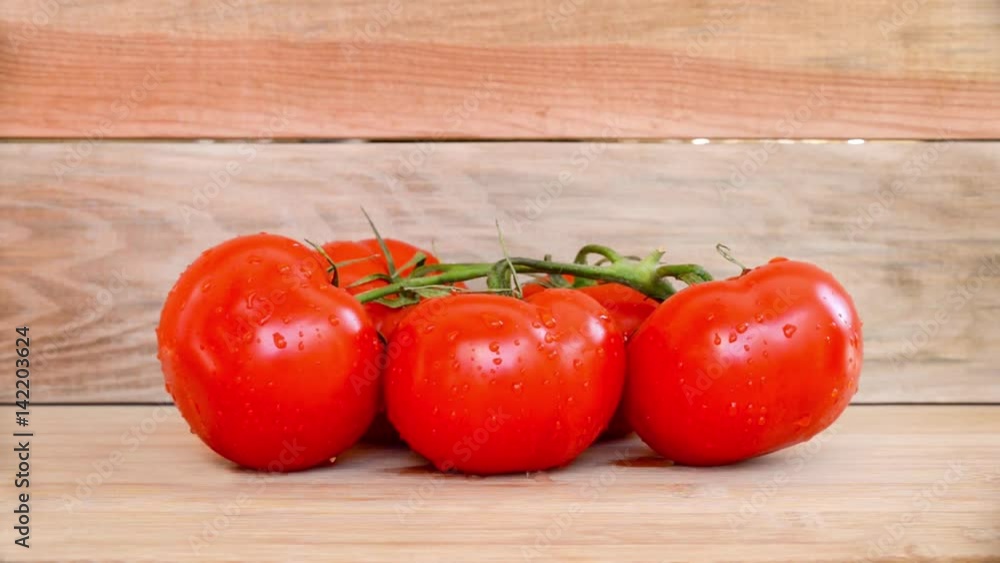 Seamless loop, fresh branch of tomatoes on wooden planks background, water trickles, HD video Seamless loop, fresh branch of tomatoes on wooden planks background, water trickles, HD video