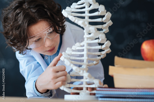 Фотография Little gifted researcher studying genetic code in the laboratory
