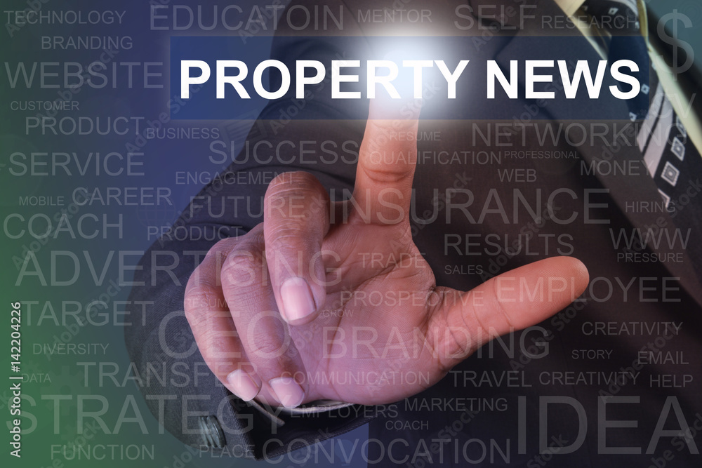 Businessman touching property news button on virtual screen Businessman touching property news button on virtual screen