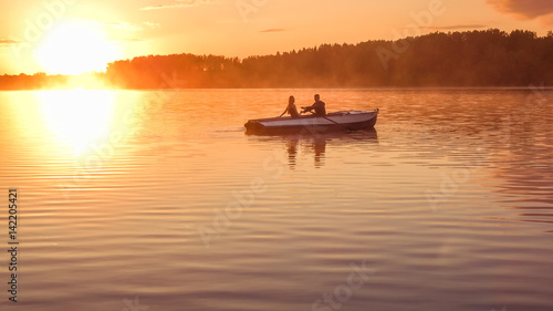 Romantic golden sunset river lake fog loving couple small rowing boat date beautiful Lovers ride during Happy woman man together relaxing water nature around © marmoset