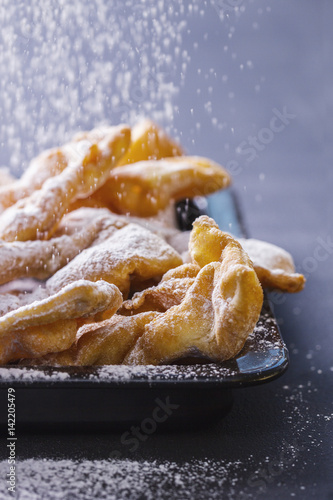 Sprinkling powdered sugar on faworki