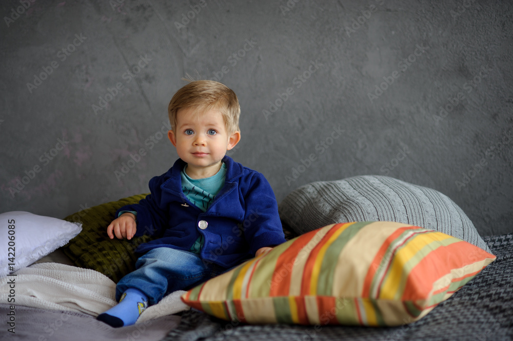 Little boy sits on a bed. Little boy sits on a bed.
