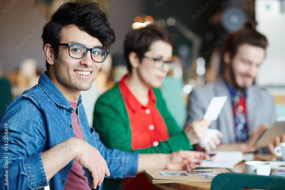 Fototapeta premium Young creative designer in eyeglasses looking at camera during work