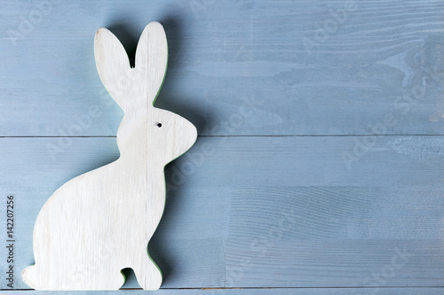 Wooden spring easter bunny figurine on grey natural background.
