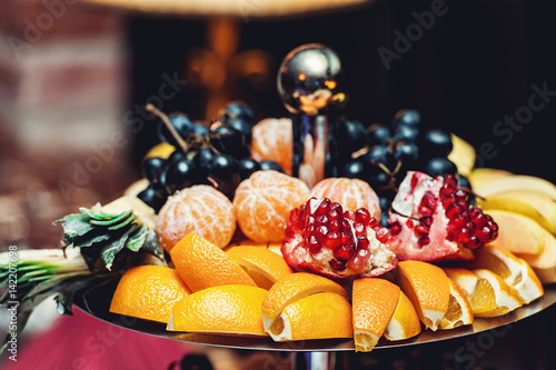 sliced fruits on a stand on a white table