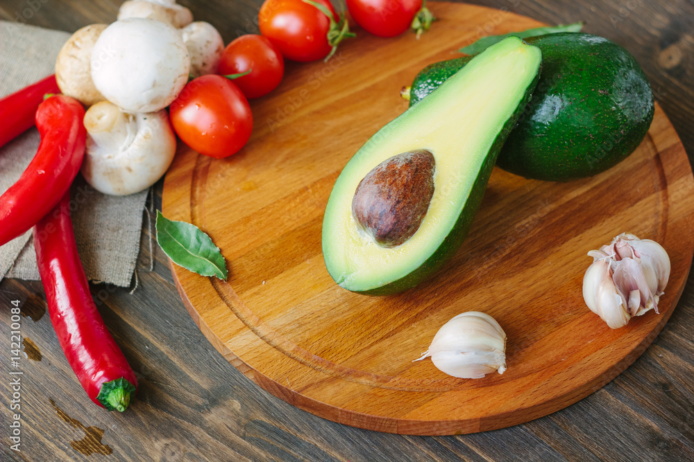 Avocado fruit on wooden board with other vegetables. Avocado fruit on wooden board with other vegetables.