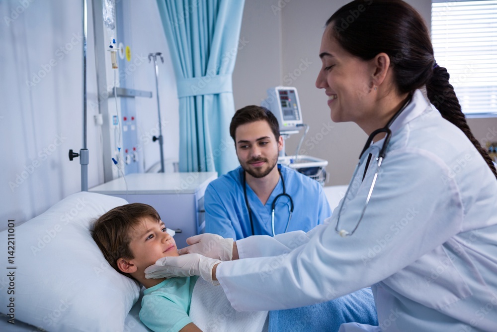 Doctors examining patient in ward Doctors examining patient in ward