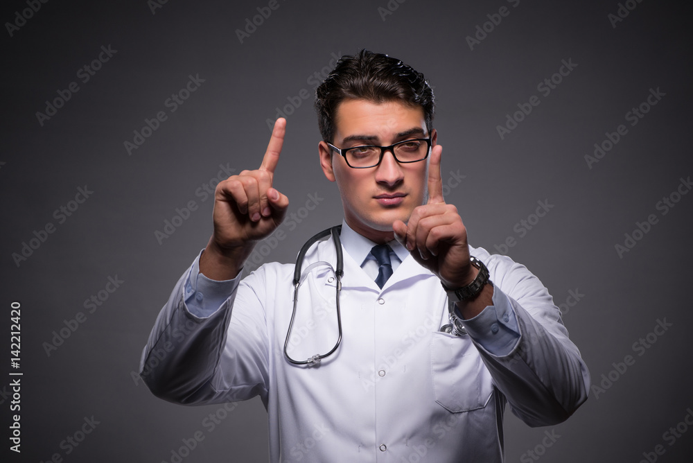 Fototapeta premium Young doctor against dark background