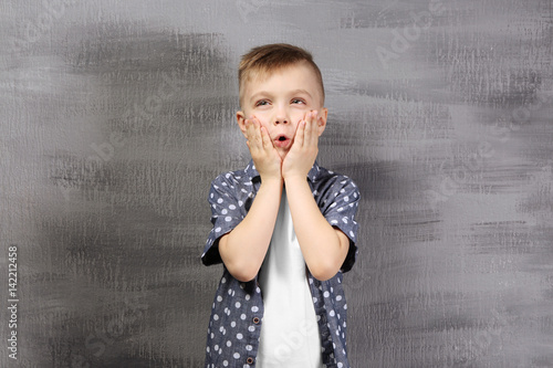 Cute little boy on color ba...