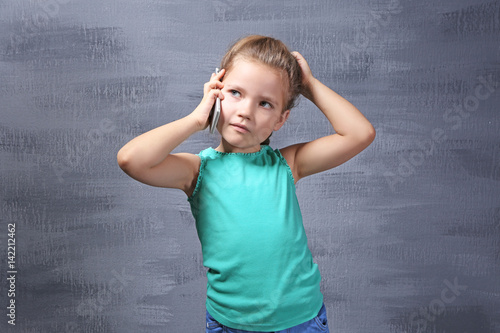 Cute little girl talking by...