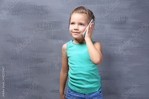 Cute little girl talking by...