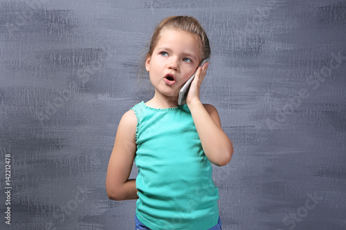 Cute little girl talking by...