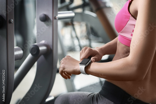 Young woman with fitness tracker in gym, closeup © Africa Studio