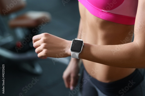 Young woman with fitness tracker in gym, closeup