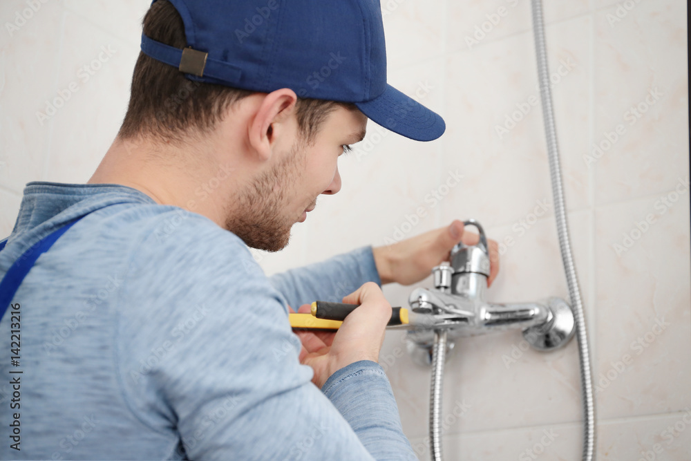 Plumber fixing faucet in bathroom Plumber fixing faucet in bathroom