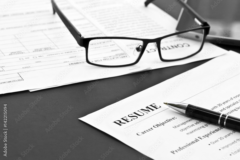 Closeup of resume with pen and glasses on the table Closeup of resume with pen and glasses on the table