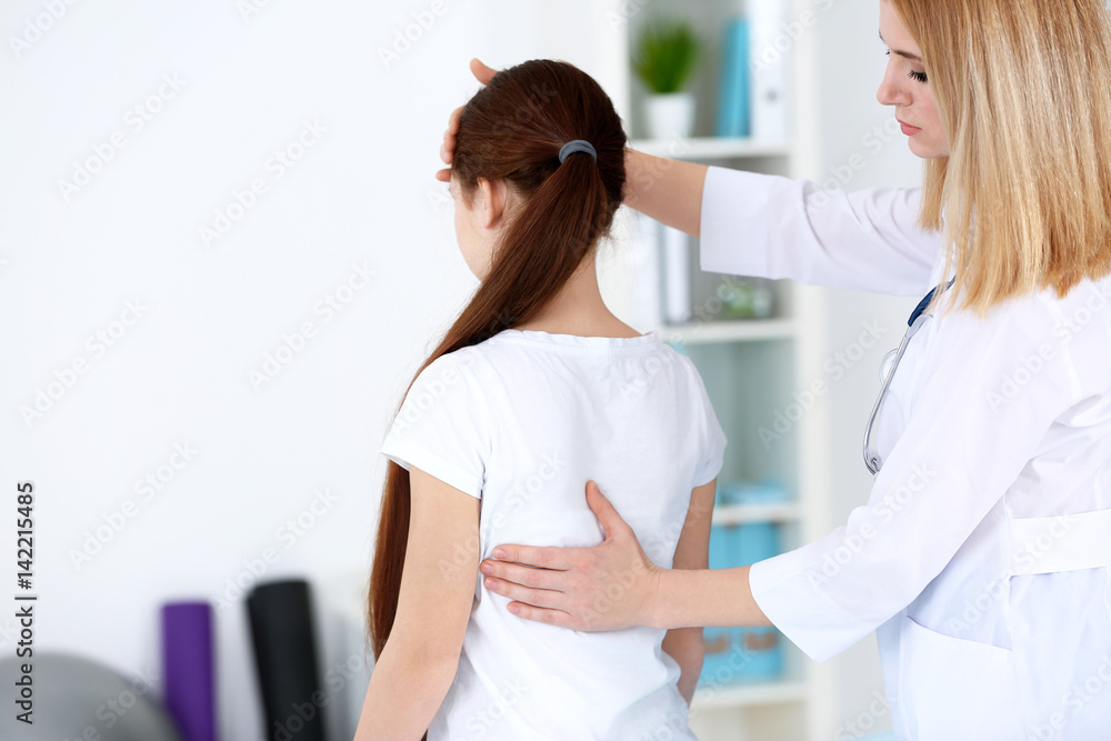 Incorrect posture concept. Physiotherapist examining and correcting girl's back Incorrect posture concept. Physiotherapist examining and correcting girl's back