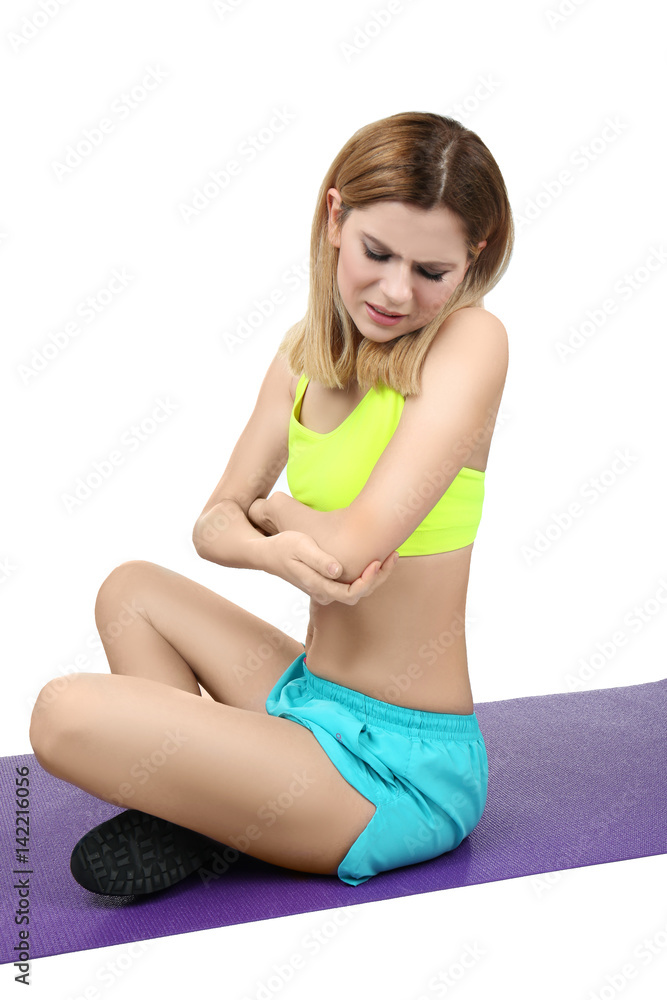 Young sporty woman suffering from pain in elbow on white background