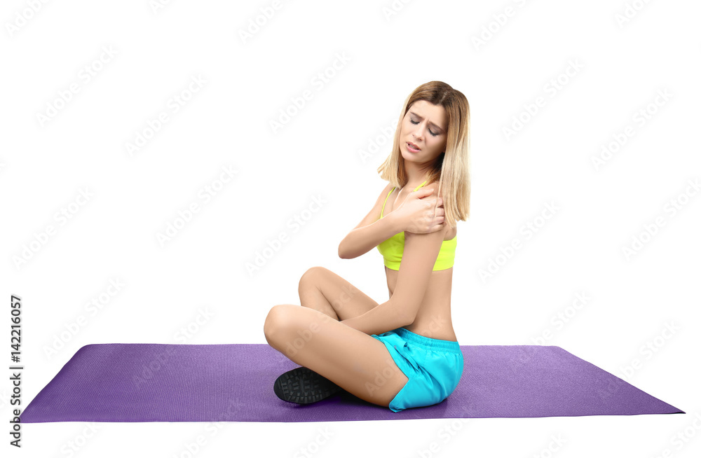 Young sporty woman suffering from pain in shoulder on white background Young sporty woman suffering from pain in shoulder on white background