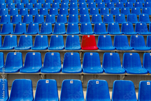 Quadro em tela Dark blue rows of seats on the stadium. One red seat.
