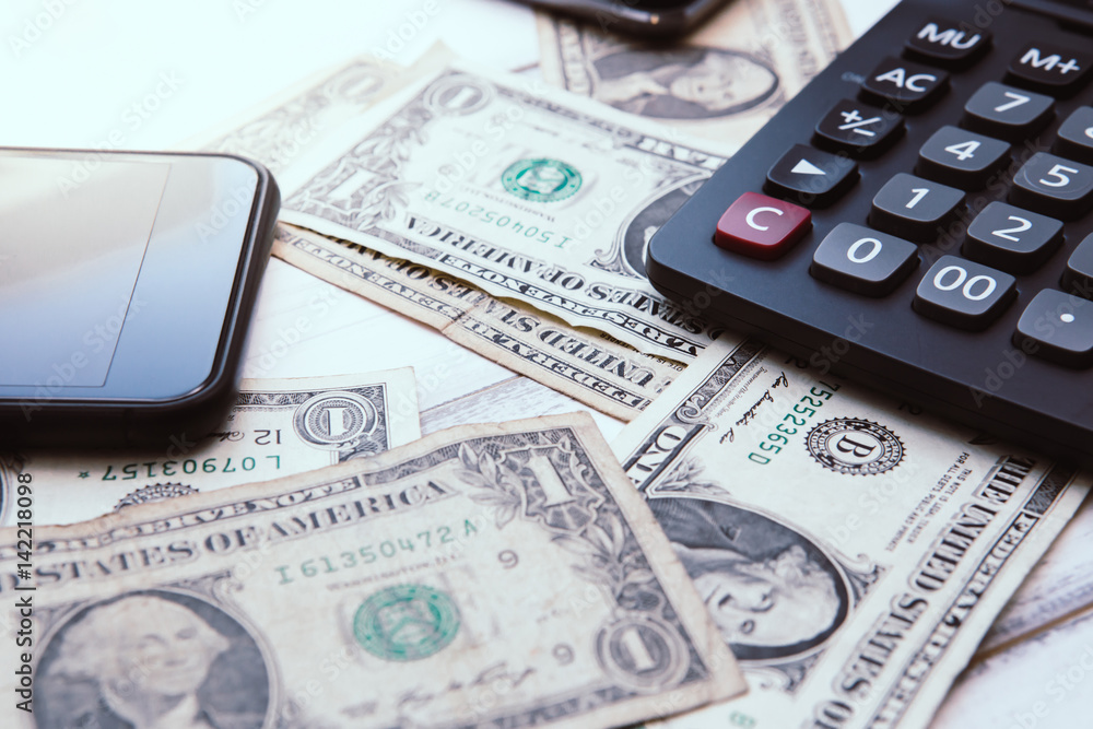 Calculator with american dollars on the wooden table background, finance concept, pencil, phone Calculator with american dollars on the wooden table background, finance concept, pencil, phone