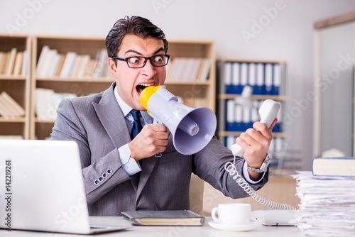 Angry businessman with too much work in office photo