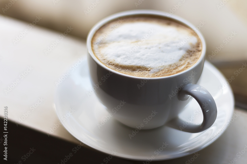 Hot coffee in a white cup is at the window. Hot coffee in a white cup is at the window.