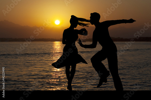 Schilderij op canvas Silhouette couple in the active ballroom dance on sunset