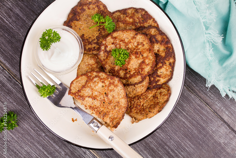 Liver Patties with Sour Cream and Parsley. Liver Cakes or Fritters of Liver. Healthy snack or take-away lunch bites. View from above, top studio shot Liver Patties with Sour Cream and Parsley. Liver Cakes or Fritters of Liver. Healthy snack or take-away lunch bites. View from above, top studio shot