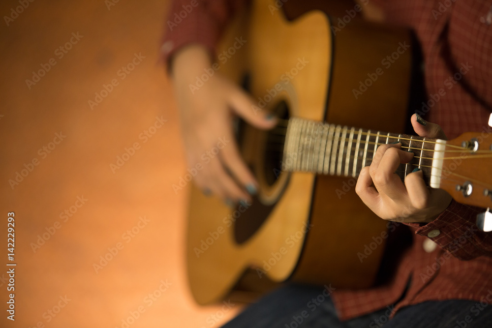 Fototapeta premium women playing acoustic guitar close-up