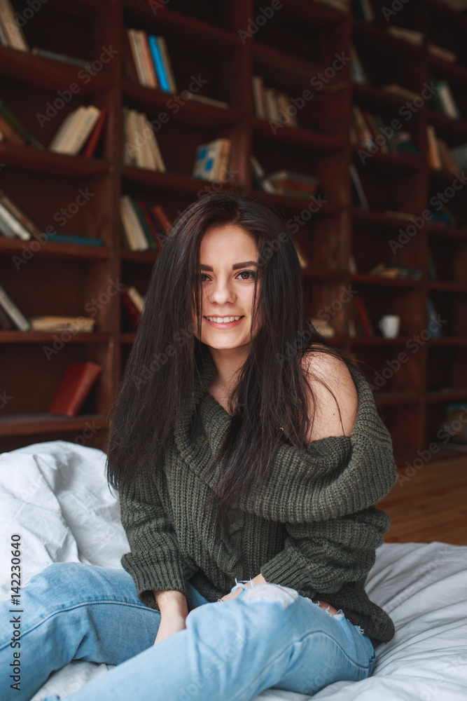 Beautiful girl with dark hair sitting on the bed in the morning Beautiful girl with dark hair sitting on the bed in the morning