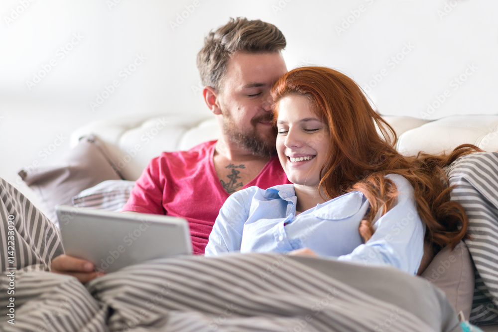 Young Couple Relaxing at Home and using tablet. Young Couple Relaxing at Home and using tablet.