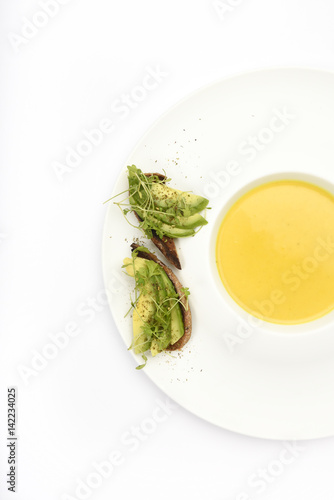 Yellow soup with pumpkin, lentils, turmeric and ginger with avocado bread photo