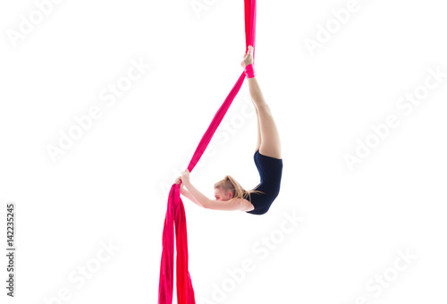 Woman hanging in aerial silks, isolated on white