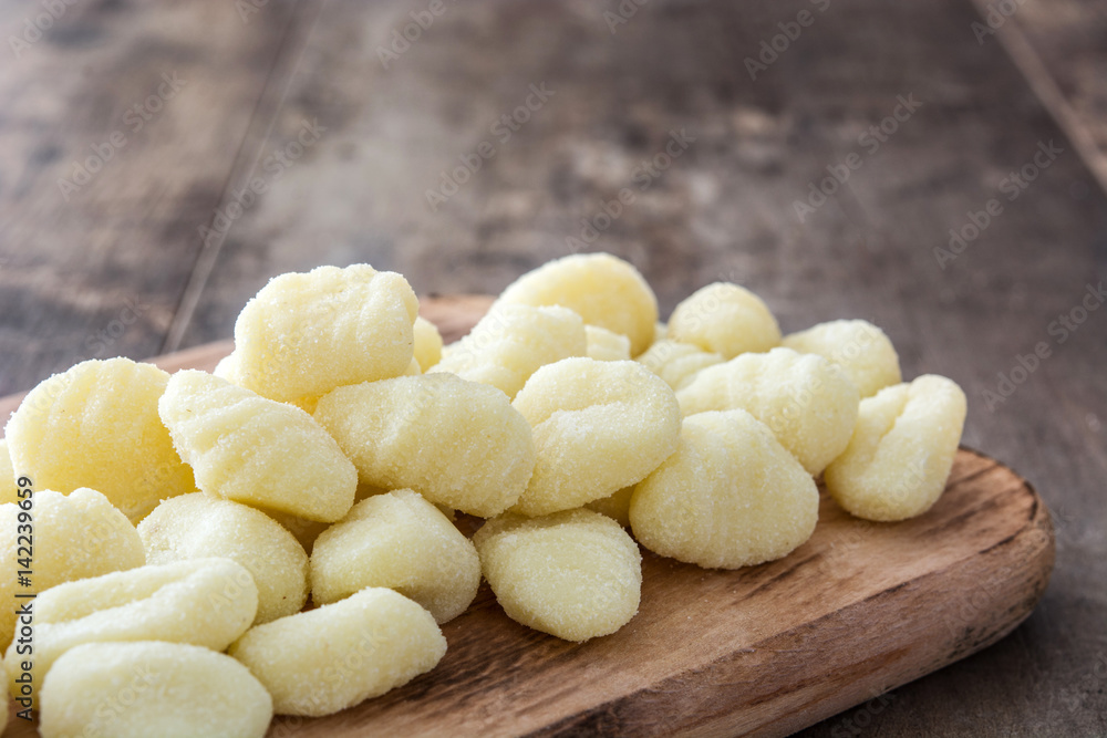 Uncooked potato gnocchi on wooden table
