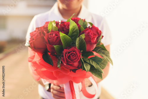 Fototapeta Naklejka Na Ścianę i Meble -  Hands holding bouquet of beautiful red roses.
