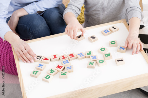 Woman and girl playing with building blocks photo