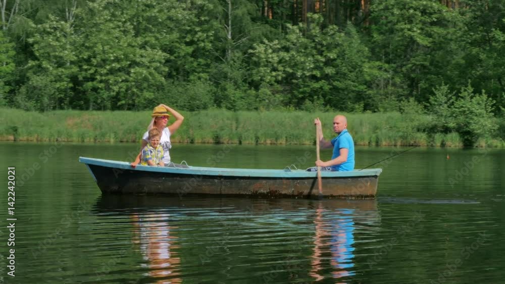 Young family relaxing in a boat on the lake Young family relaxing in a boat on the lake