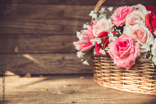 vintage flower rose in the basket on old wood background. © Quality Stock Arts