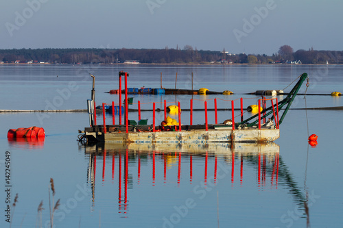 Teil einer Entschlammungsanlage auf dem Steinhuder Meer. Der Binnensee wird über schwimmende bunte Saugleitungen vom Grundschlamm befreit photo