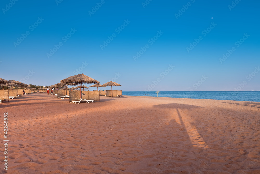 Wakacje w Egipcie. Plaża na wybrzeżu morza czerwonego przy ekskluzywnym hotelu.
 - obrazy, fototapety, plakaty 