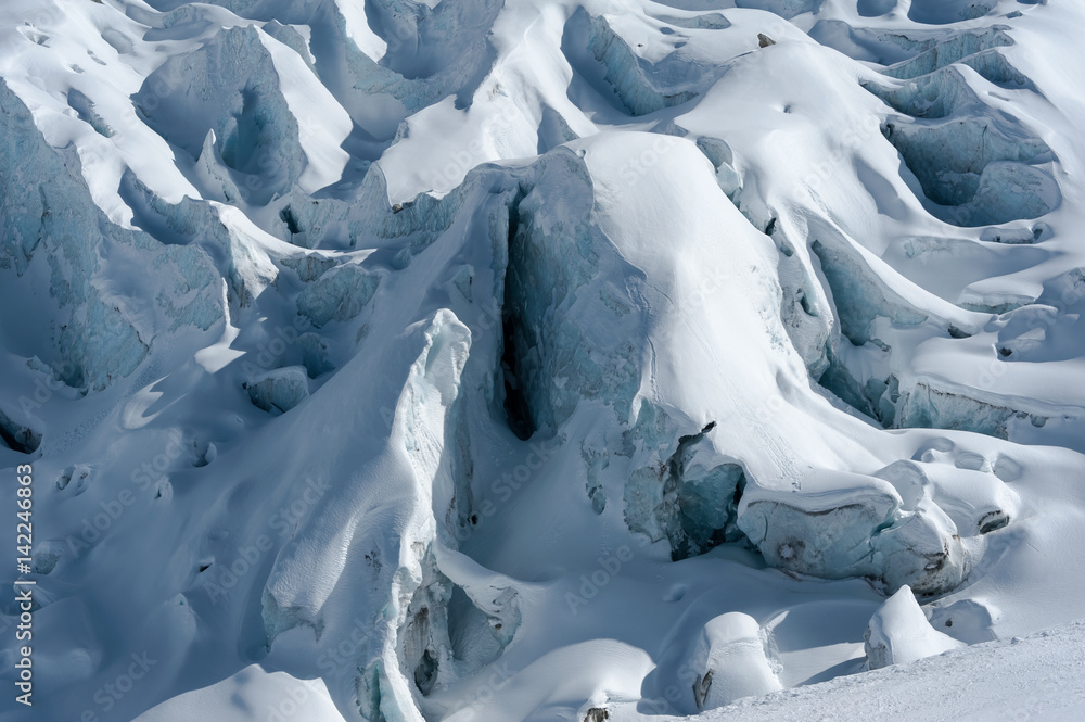 Detail of glacier flow and crevasses covered by snow in winter
