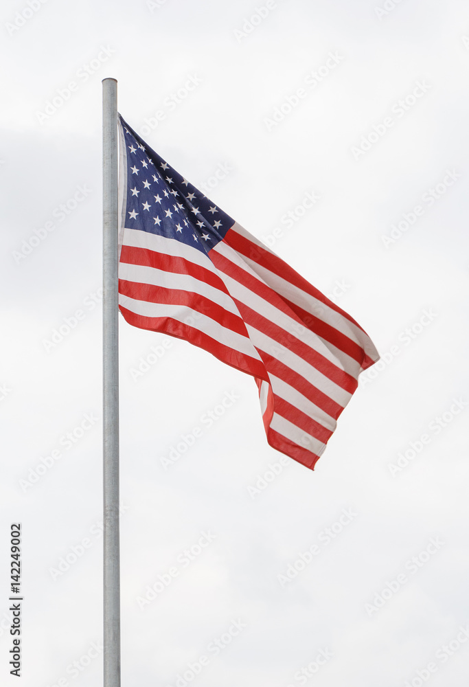USA flag on flagpole against cloudy sky